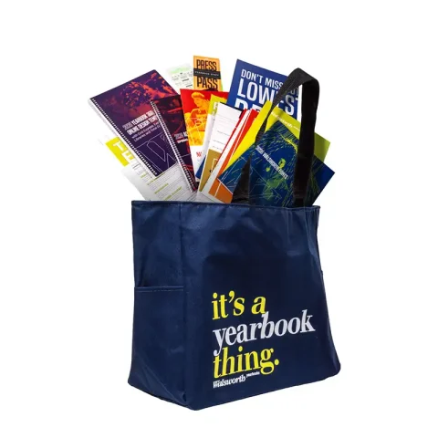 A yearbook tote with a lot of materials in it.