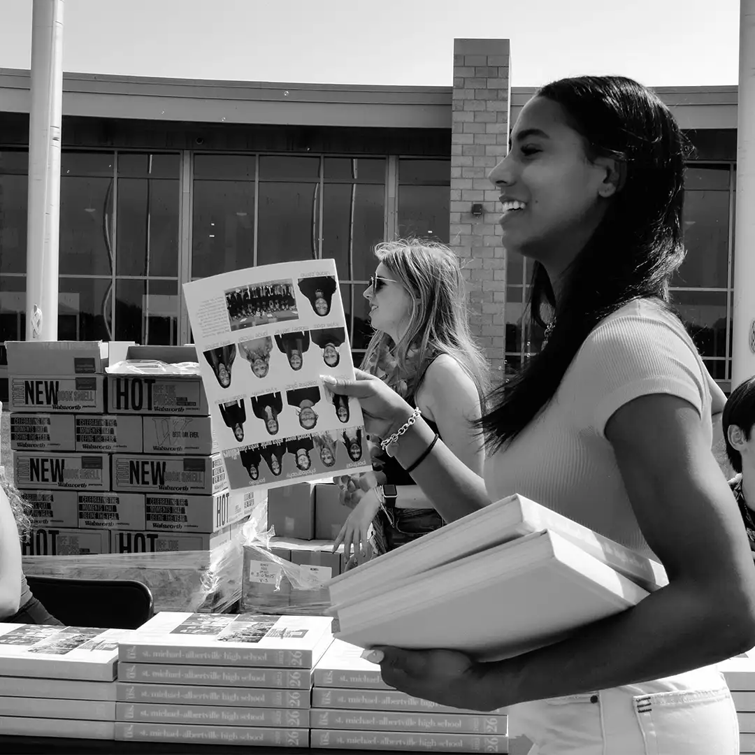 A student holding a yearbook on yearbook distribution day.